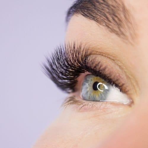 Vrouw laat het mooie resultaat zien na wimperextensions