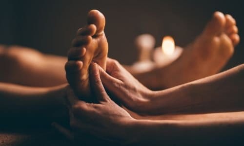 Vrouw geniet van een voetreflexmassage en ontspant haar lichaam en geest